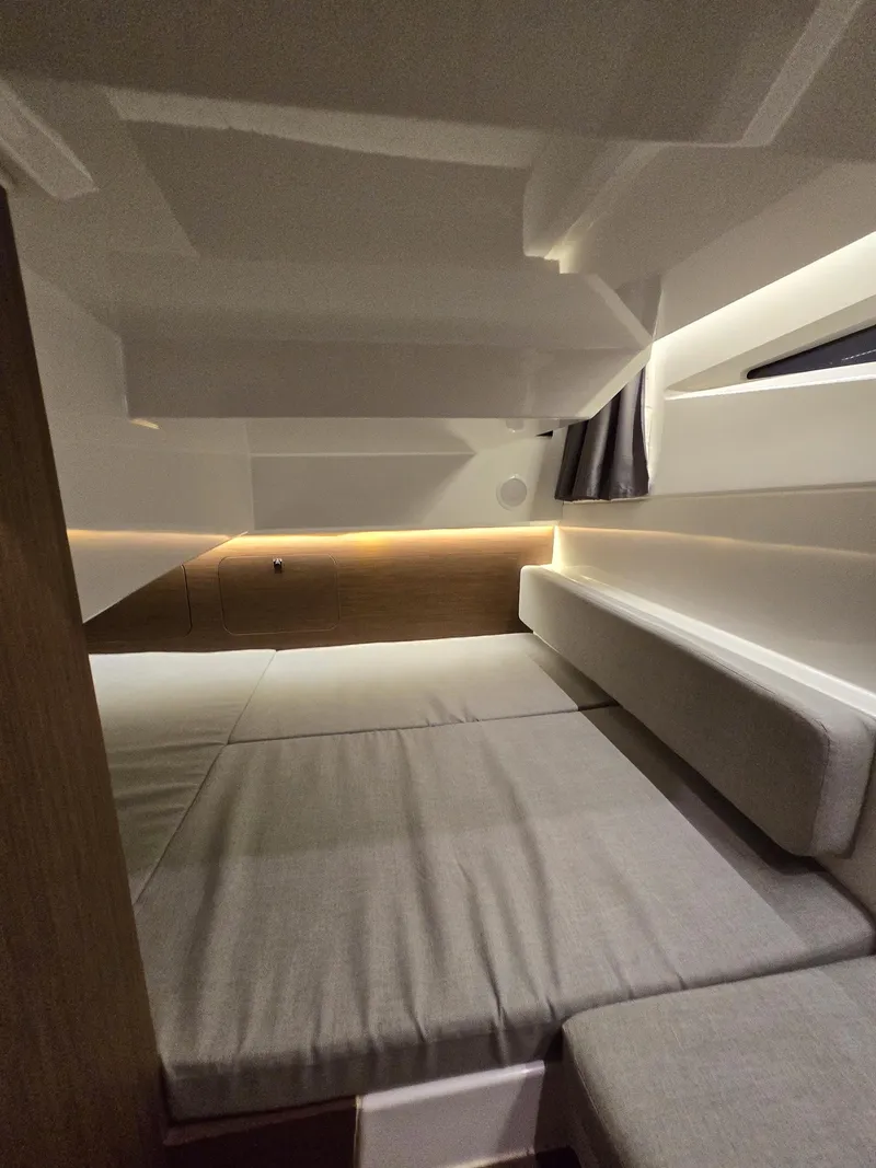 Slide: The Image of 2021 Jeanneau NC895 cabin interior with modern design and cozy bedding. - 17