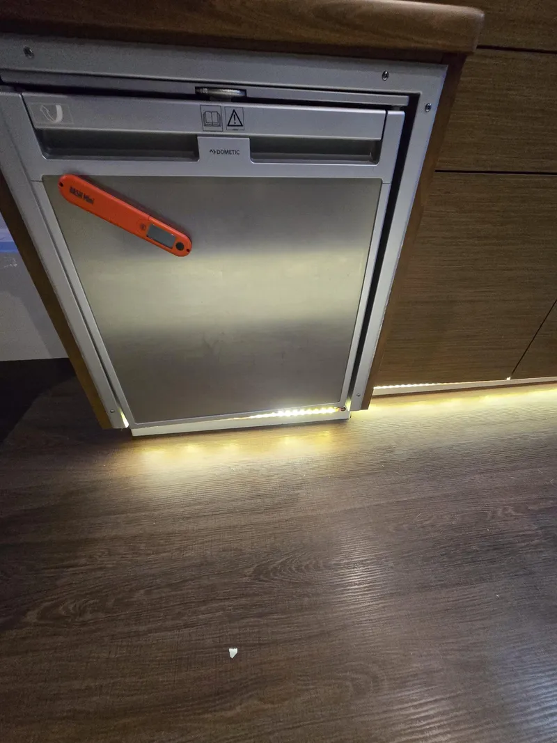 Slide: The Image of Stainless steel appliance in 2021 Jeanneau NC895 boat interior with wood accents and ambient lighting. - 22