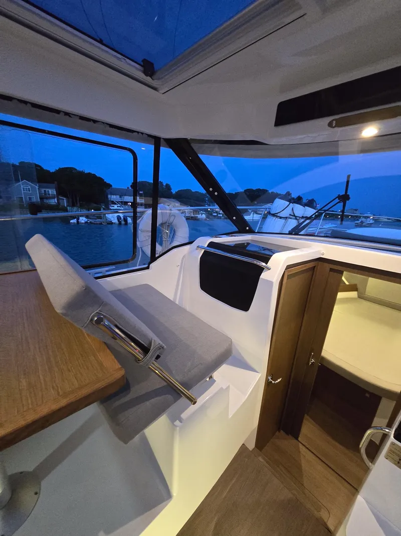 Slide: The Image of Interior of 2021 Jeanneau NC895 boat with seating and scenic waterfront view. - 24
