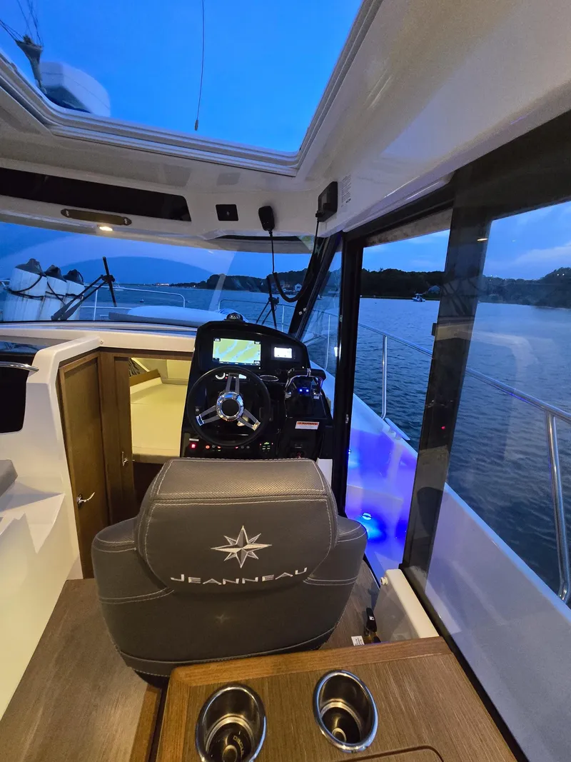 Slide: The Image of 2021 Jeanneau NC895 boat interior with steering console, lake view, and modern design. - 25