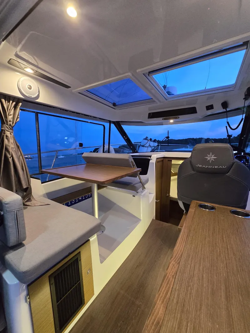 Slide: The Image of Interior of 2021 Jeanneau NC895 boat with seating, table, and panoramic windows. - 26