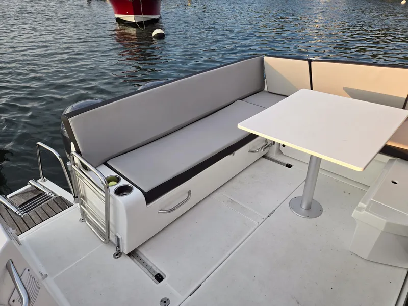 Slide: The Image of 2021 Jeanneau NC895 boat deck with seating and table by the water. - 29