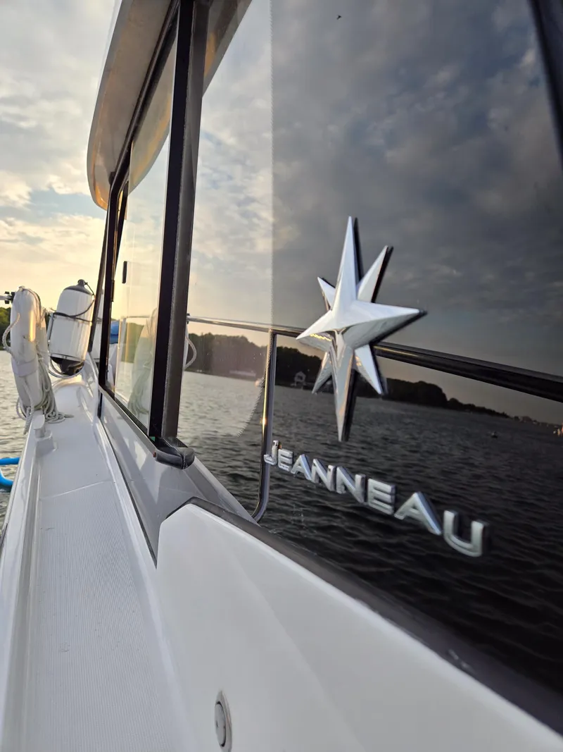 Slide: The Image of 2021 Jeanneau NC895 boat reflecting on water at sunset. - 30