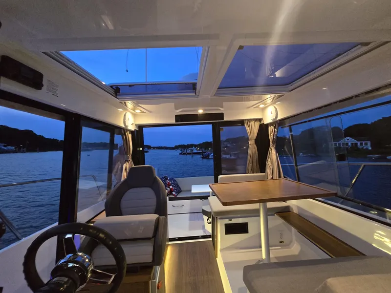 Slide: The Image of Interior of 2021 Jeanneau NC895 boat with scenic water view at dusk. - 5