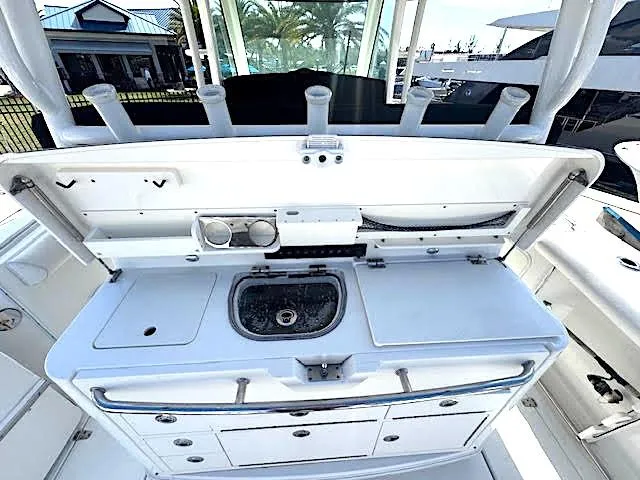 Slide: The Image of 2016 Boston Whaler 350 Outrage boat interior with sink and storage compartments. - 14