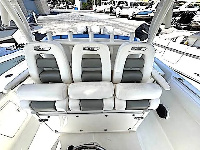 Slide: The Image of 2016 Boston Whaler 350 Outrage boat seating, white and gray upholstery, docked at marina. - 17