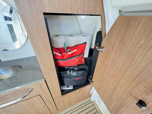 Slide: The Image of 2016 Boston Whaler 350 Outrage cabin storage with supplies and wooden cabinetry. - 44