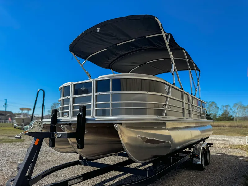Slide: The Image of 2024 Berkshire 24RFXLE pontoon boat with canopy on trailer, under clear blue sky. - 12