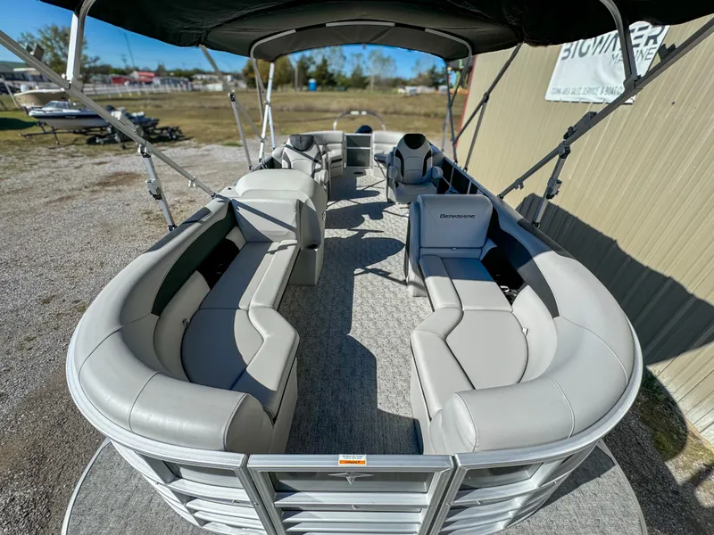 Slide: The Image of 2024 Berkshire 24RFXLE pontoon boat with spacious seating and canopy, parked outdoors. - 7