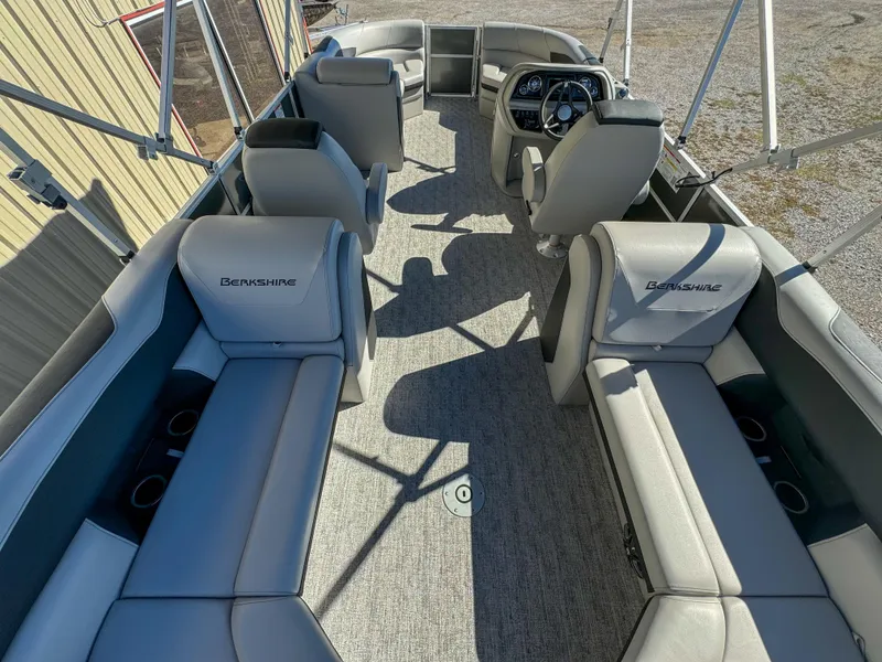 Slide: The Image of 2024 Berkshire 24RFXLE pontoon boat interior with gray seating and steering console. - 9