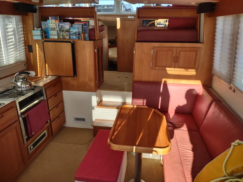 Slide: The Image of Interior of a 2006 Nordic Tug 32, featuring a cozy dining area and compact kitchen. - 12