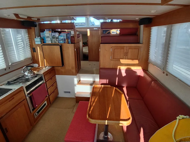 Slide: The Image of Interior of a 2006 Nordic Tug 32, featuring a cozy dining area and compact kitchen. - 15