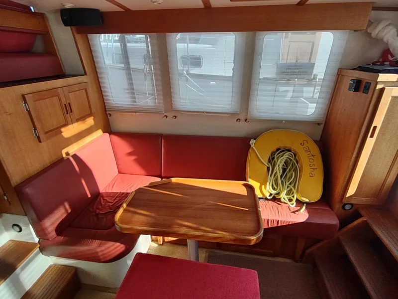 Slide: The Image of Interior of 2006 Nordic Tug 32 with red seating and wooden table. - 17