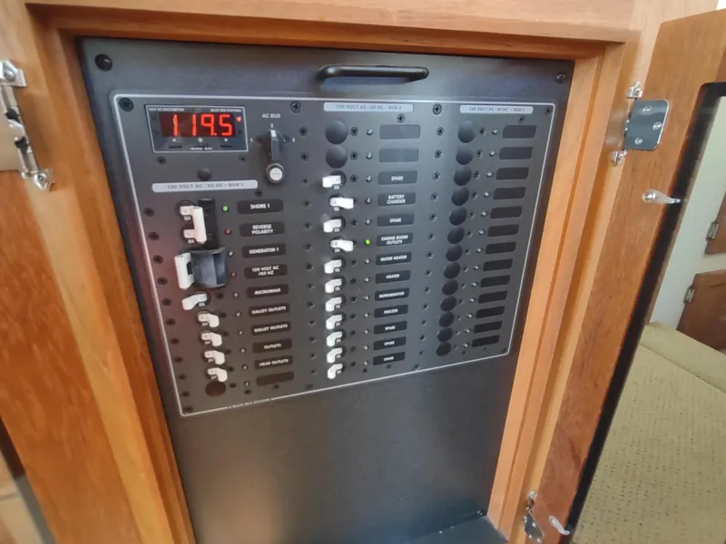 Slide: The Image of Electrical panel of a 2006 Nordic Tug 32 boat, featuring switches and voltage display. - 26