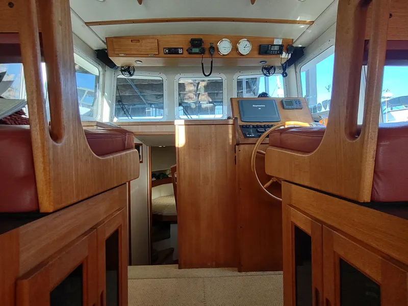Slide: The Image of Interior of 2006 Nordic Tug 32, featuring wooden helm and seating. - 28
