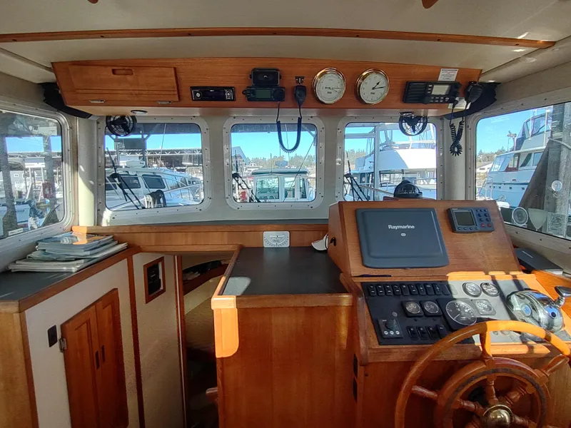 Slide: The Image of 2006 Nordic Tug 32 boat interior with navigation equipment and wooden steering wheel. - 29