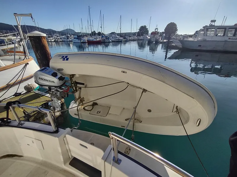 Slide: The Image of Nordic Tug 32 (2006) with dinghy and Honda motor in a marina setting. - 8