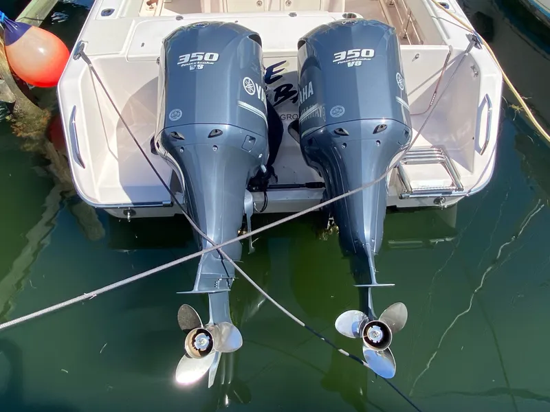 Slide: The Image of Twin Yamaha 350 engines on a 2016 Grady-White Canyon 306 boat, docked in water. - 11