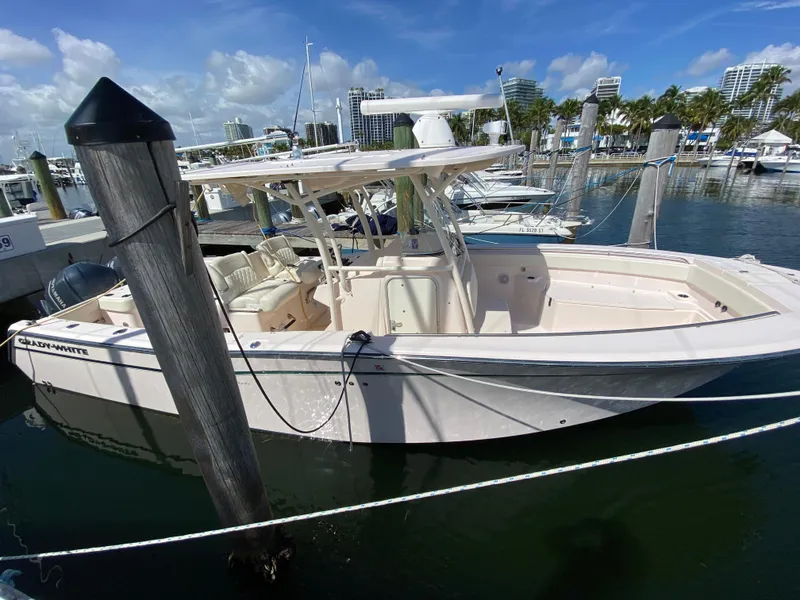Slide: The Image of 2016 Grady-White Canyon 306 boat docked in a marina under a clear blue sky. - 2