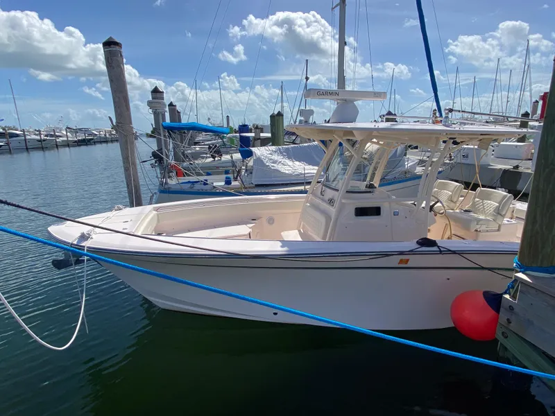 Slide: The Image of 2016 Grady-White Canyon 306 boat docked in a marina under a clear blue sky. - 3