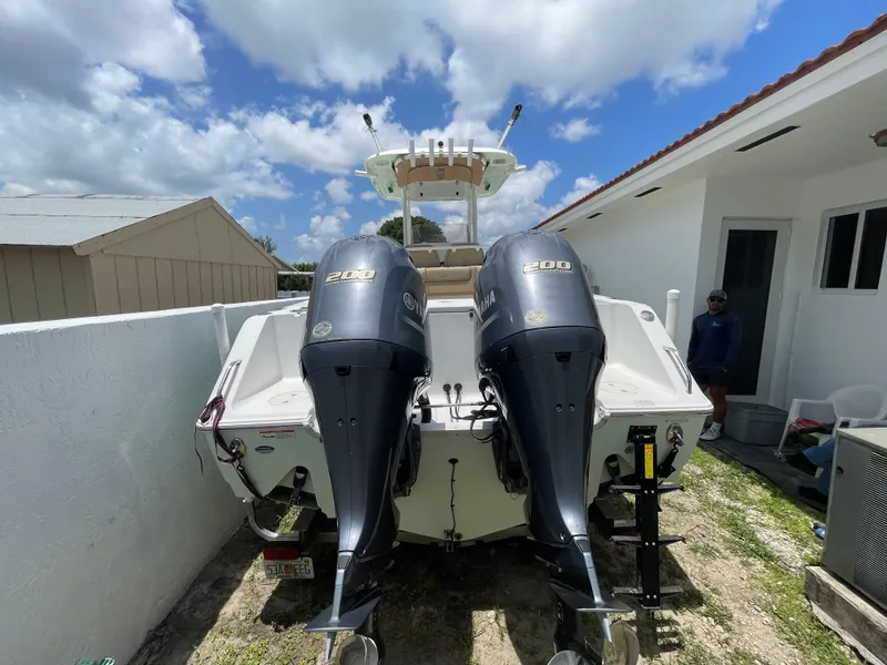 Slide: The Image of 2017 Sea Hunt Gamefish 27 with Coffin Box, dual engines, parked outdoors under a cloudy sky. - 10