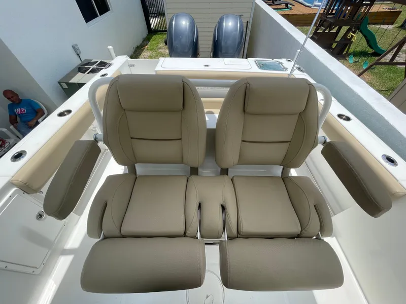 Slide: The Image of 2017 Sea Hunt Gamefish 27 boat seats with dual engines in the background. - 8