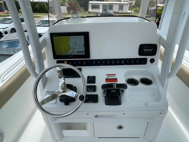 Slide: The Image of 2017 Sea Hunt Gamefish 27 helm with steering wheel, controls, and navigation display. - 9