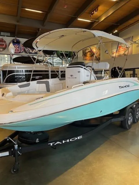 Slide: The Image of 2025 Tahoe 2150 CC boat with canopy, displayed indoors on a trailer. - 4