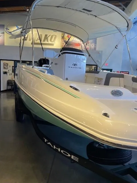 Slide: The Image of 2025 Tahoe 2150 CC boat displayed in showroom with canopy and sleek design. - 8