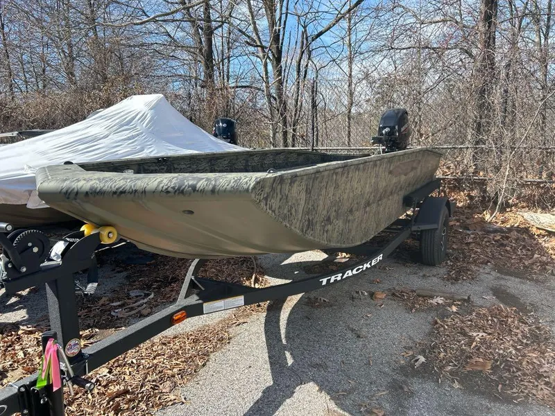 Slide: The Image of 2025 Tracker Grizzly 1650 T Prairie Wings Edition boat on trailer in wooded area. - 3