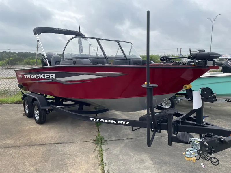 The Image of 2025 Tracker Targa V-18 Combo boat in red on a trailer, parked outdoors. - 0