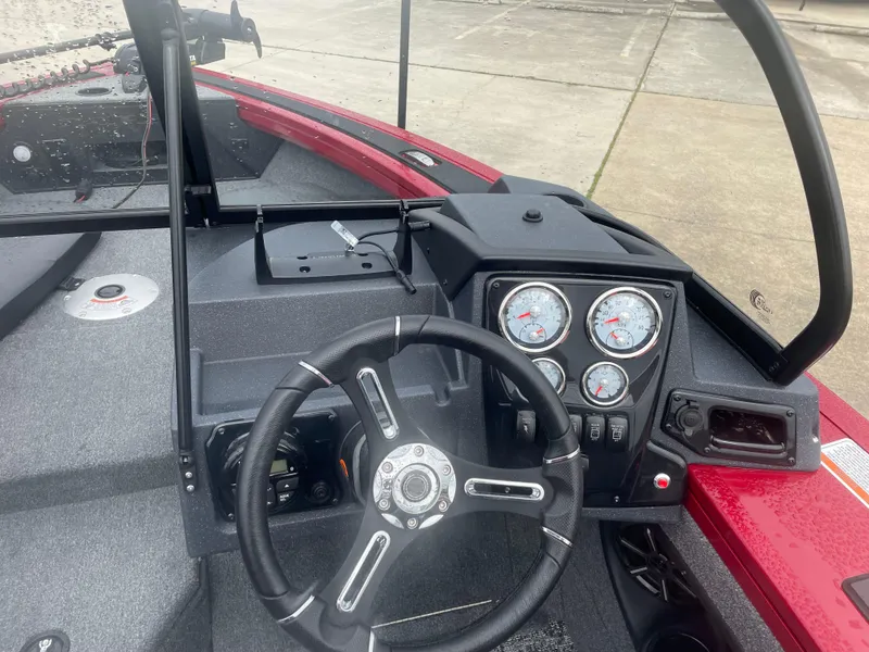 Slide: The Image of 2025 Tracker Targa V-18 Combo boat dashboard with steering wheel and gauges. - 7