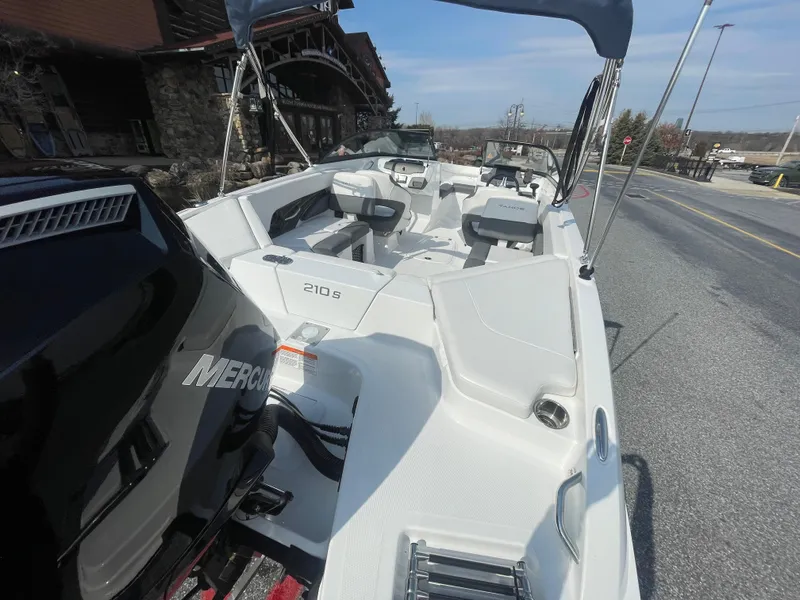 Slide: The Image of 2024 Tahoe 210 S boat with Mercury engine, parked on a street. - 4