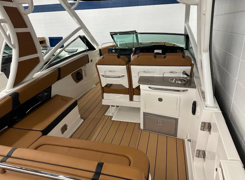 Slide: The Image of 2023 Chaparral 280 OSX boat interior with tan seating and modern amenities. - 4
