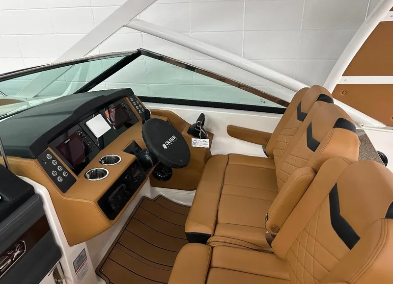 Slide: The Image of 2023 Chaparral 280 OSX boat interior with tan leather seats and modern dashboard. - 8