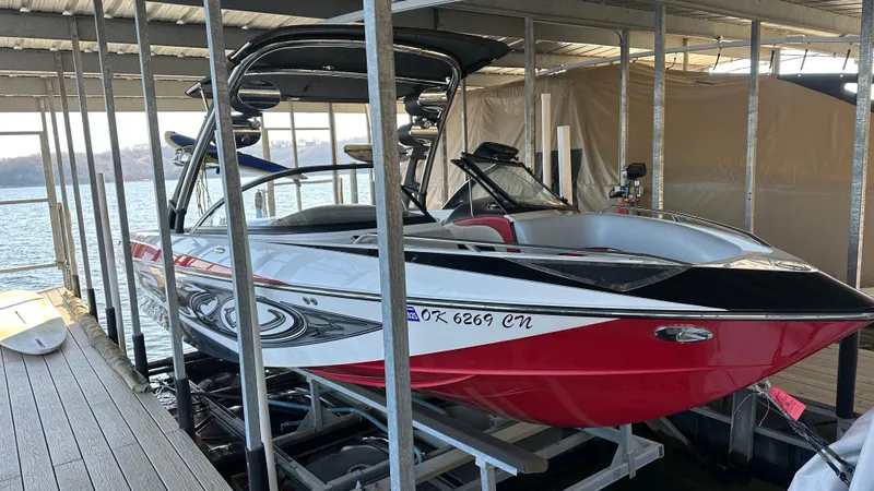 Slide: The Image of 2007 Malibu 247LSV boat docked, featuring sleek design and vibrant red accents. - 11