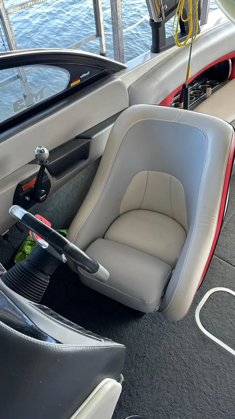 Slide: The Image of Interior of a 2007 Malibu 247LSV boat with a gray captain's seat and steering wheel. - 3