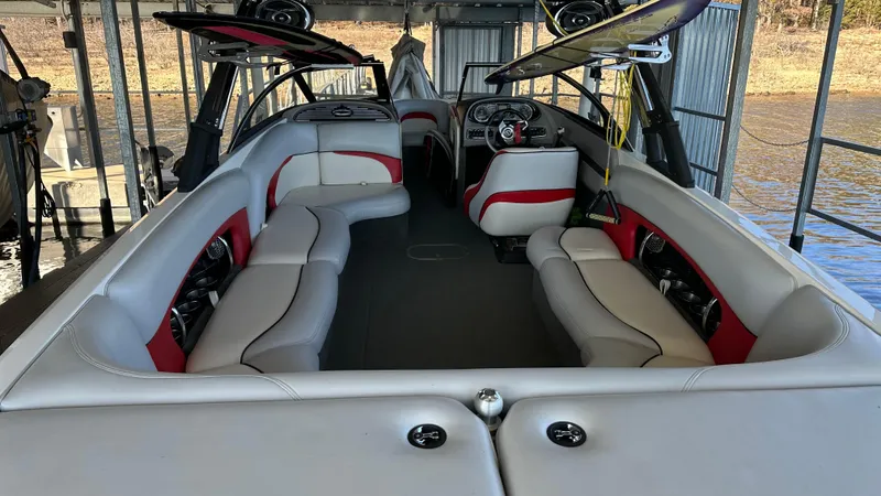 Slide: The Image of 2007 Malibu 247LSV boat interior with red and white seating, docked by the water. - 9