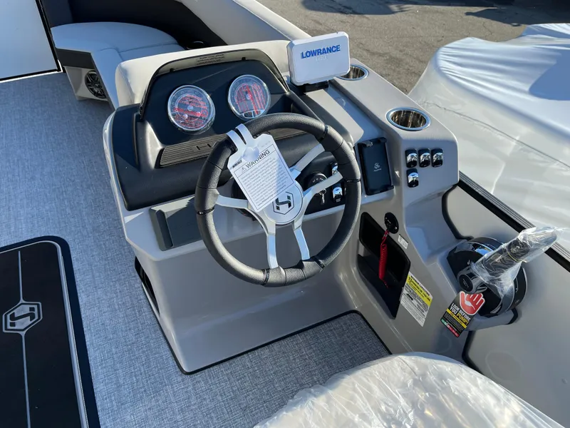 Slide: The Image of 2025 Harris Cruiser 230 boat dashboard with steering wheel and control panel. - 2
