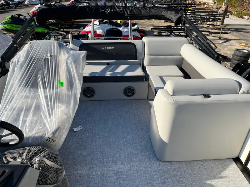 Slide: The Image of 2025 Harris Cruiser 230 boat interior with gray seating and covered equipment. - 6