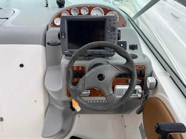 Slide: The Image of 2006 Bayliner 275 boat helm with steering wheel and navigation system. - 12