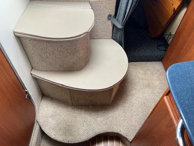 Slide: The Image of Interior steps of a 2006 Bayliner 275 boat, featuring carpeted flooring and wooden accents. - 20