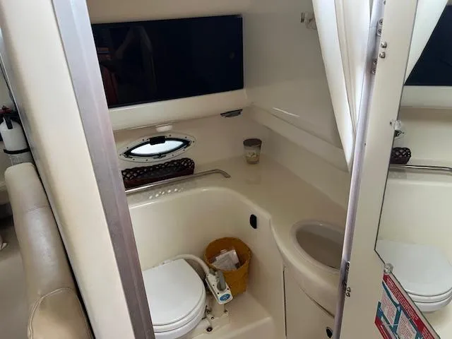 Slide: The Image of 2006 Bayliner 275 boat bathroom interior with toilet and sink. - 21