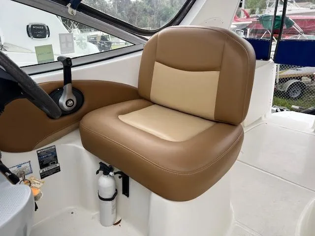 Slide: The Image of 2006 Bayliner 275 boat interior with tan captain's seat and steering wheel. - 24