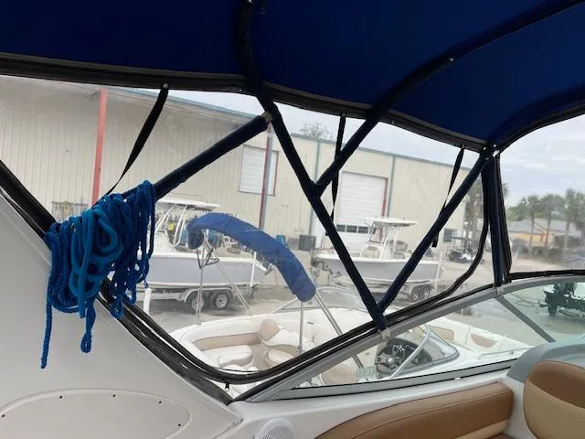 Slide: The Image of Interior view of a 2006 Bayliner 275 boat with blue canopy and coiled rope. - 25