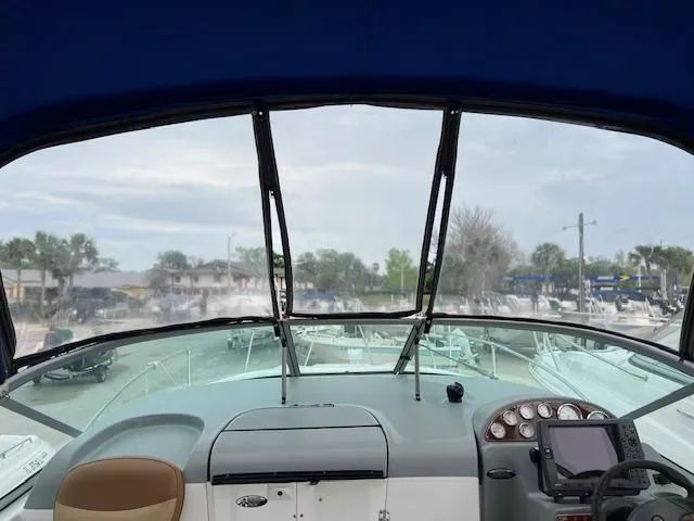 Slide: The Image of 2006 Bayliner 275 boat dashboard view with marina background. - 26