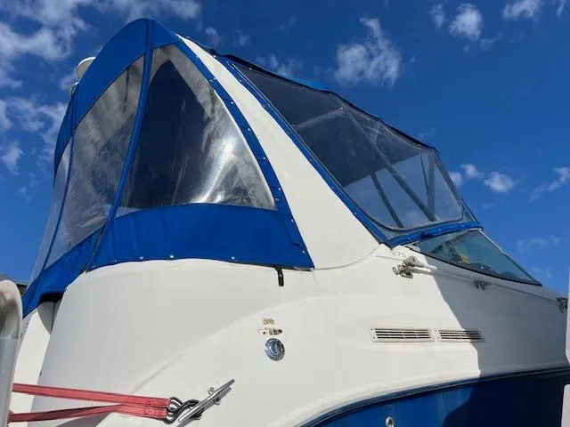 Slide: The Image of 2006 Bayliner 275 boat with blue canopy against a clear sky. - 6