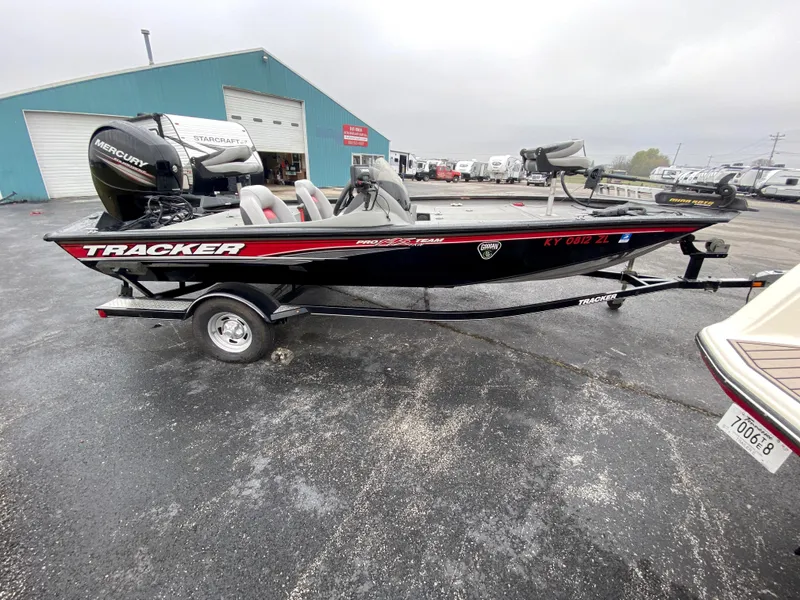 Slide: The Image of 2016 Tracker Pro Team 195 TXW boat on trailer, parked outside a warehouse. - 14