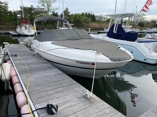 Slide: The Image of 2002 Maxum 2100 SD boat docked with cover, in a marina setting. - 3