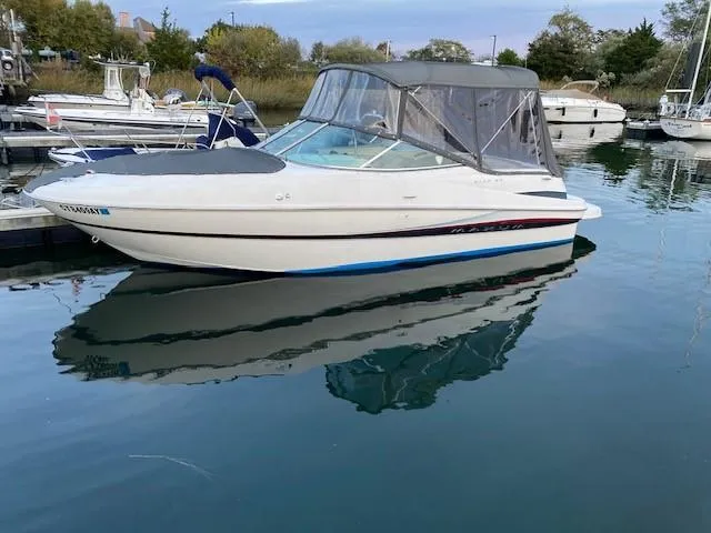 Slide: The Image of 2002 Maxum 2100 SD boat docked in a marina with a canopy cover. - 5